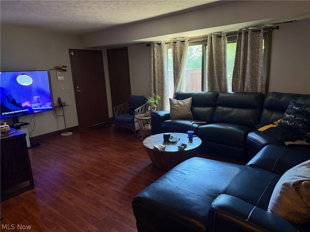 3249 Mayfield Road, Unit 13 Cleveland Heights, OH 44118 - Photo 2 of 7 Living area featuring rich wood-finish flooring, a wall-mounted television, and a sliding glass door