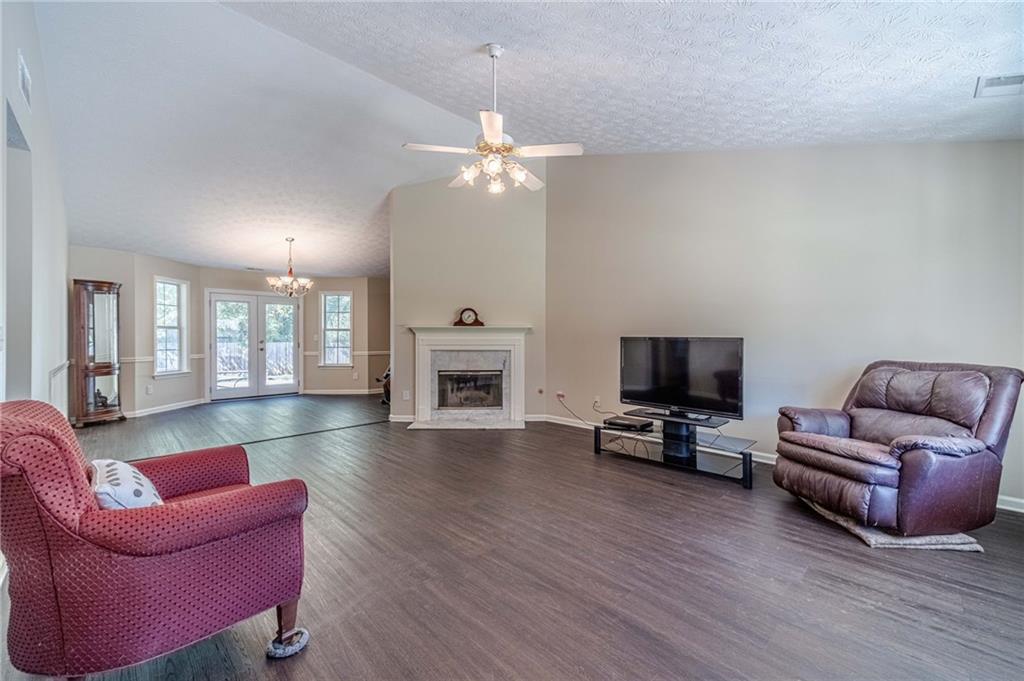 309 Magnolia Lane Monroe, GA 30655 - Photo 11 of 25 a living room with furniture a fireplace and a flat screen tv