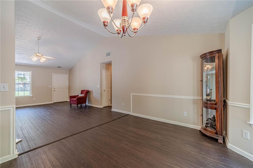 309 Magnolia Lane Monroe, GA 30655 - Photo 14 of 25 an empty room with wooden floor and a chandelier