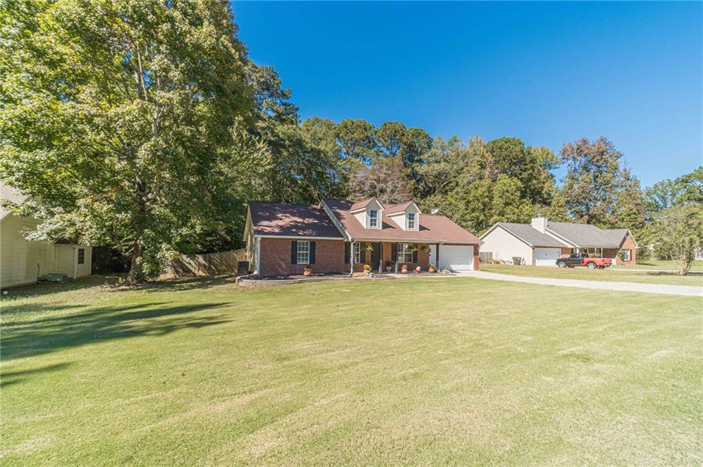 309 Magnolia Lane Monroe, GA 30655 - Photo 3 of 25 a front view of a house with a garden and trees