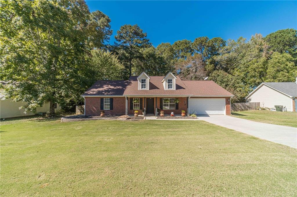 309 Magnolia Lane Monroe, GA 30655 - Photo 7 of 25 a front view of a house with a garden and trees