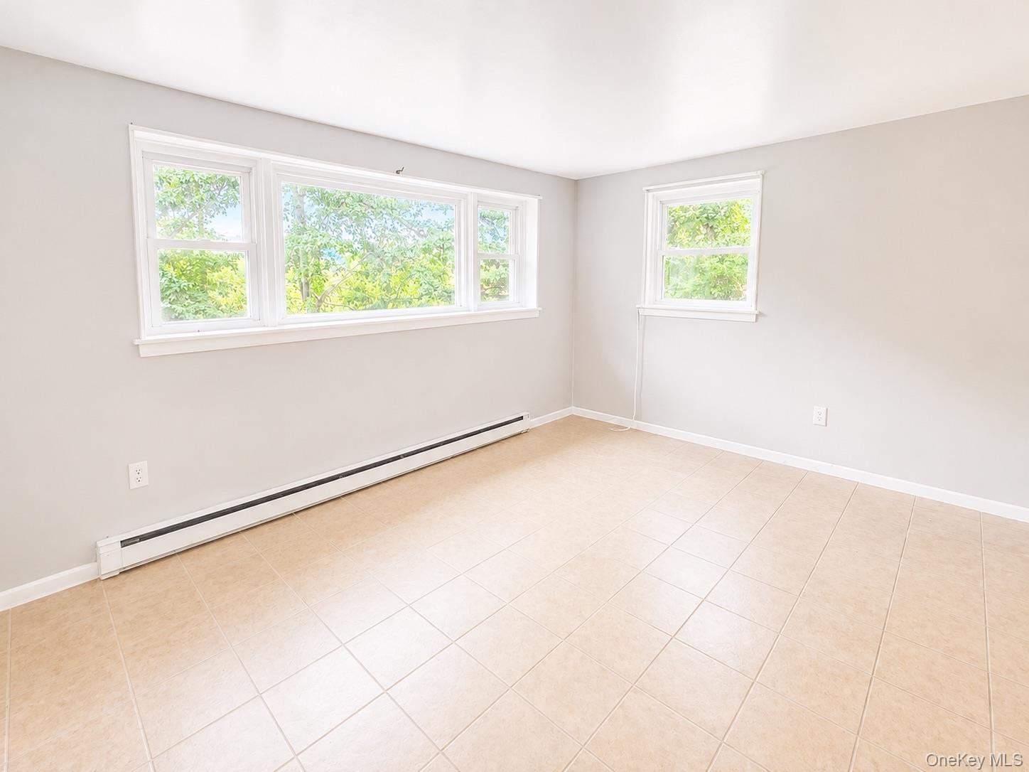 Large windows, light-toned walls, and tile flooring