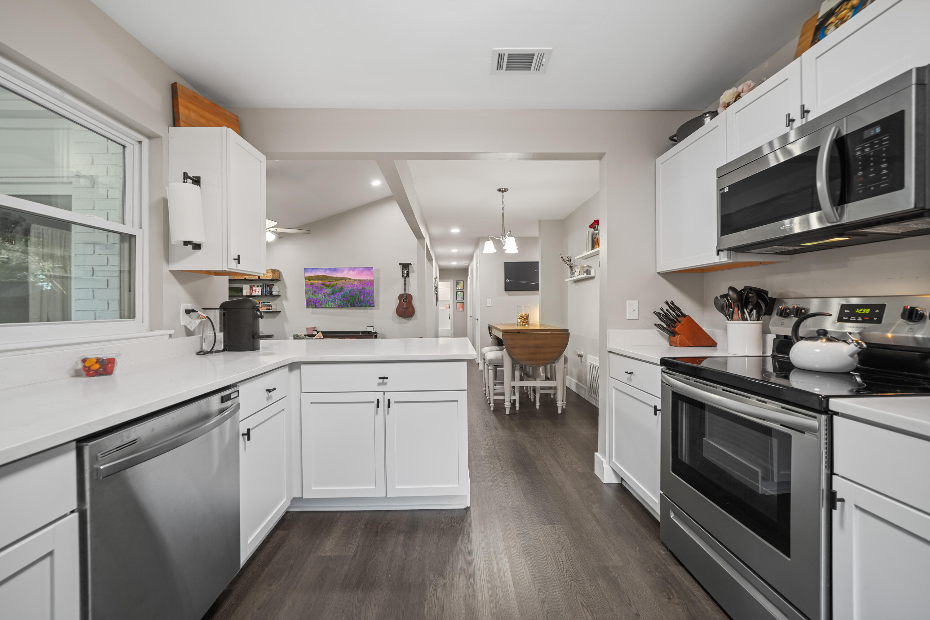 39 9th Street Shalimar, FL 32579 - Photo 5 of 37 a kitchen with stainless steel appliances granite countertop a stove a sink dishwasher and a microwave oven with wooden floor