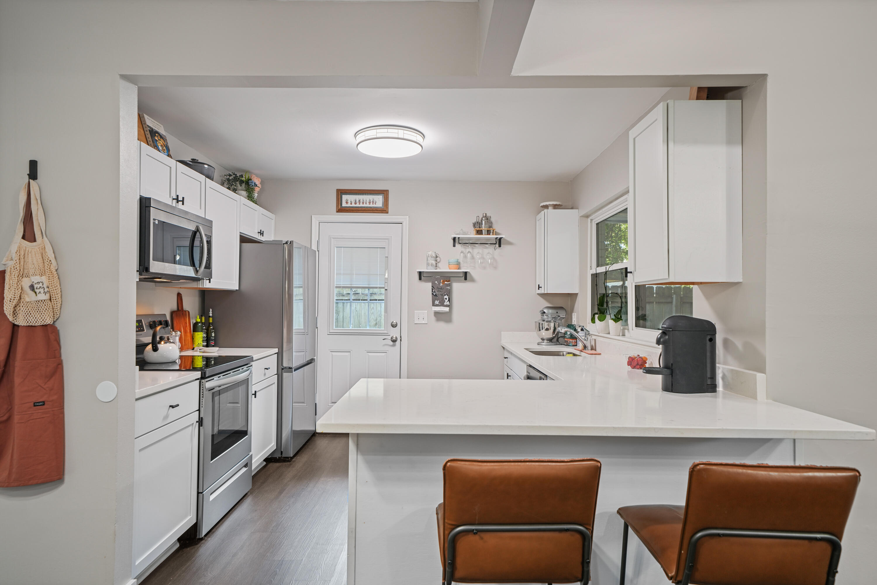 39 9th Street Shalimar, FL 32579 - Photo 9 of 37 a kitchen with stainless steel appliances a stove a sink a microwave a refrigerator and cabinets
