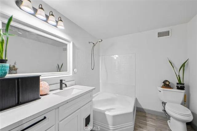 a bathroom with a sink a toilet a mirror and shower