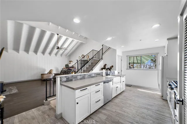 a kitchen with a sink and wooden floor