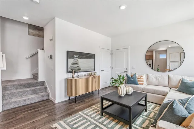 a living room with furniture a mirror and a table