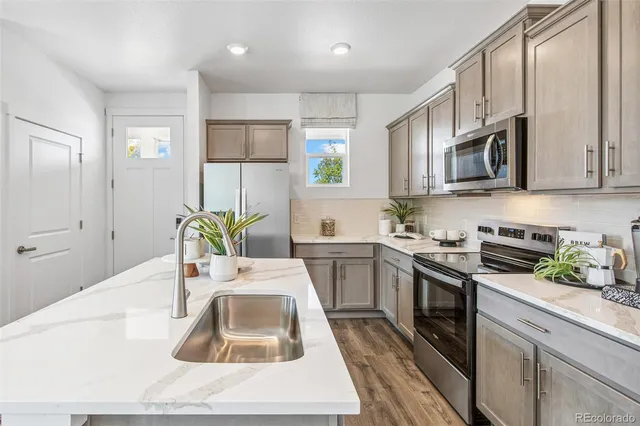 a kitchen with stainless steel appliances granite countertop a sink stove and refrigerator