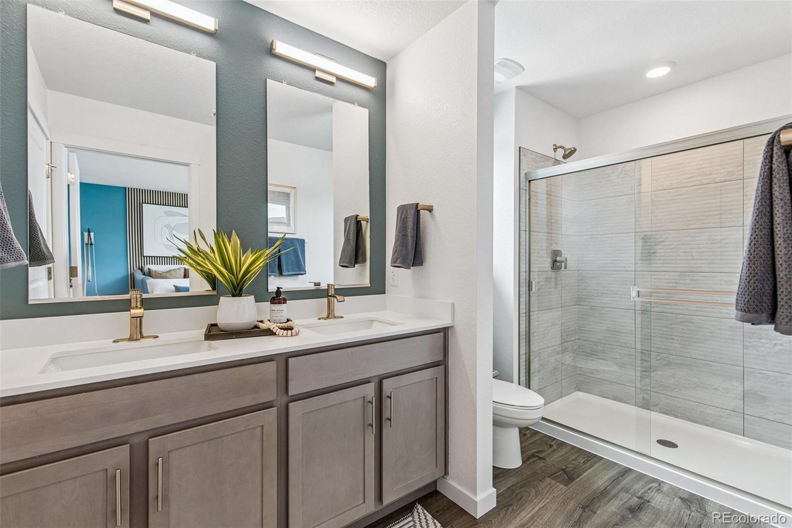 1341 South Chester Street, Unit B Denver, CO 80247 - Photo 8 of 14 a bathroom with a double vanity sink toilet and shower