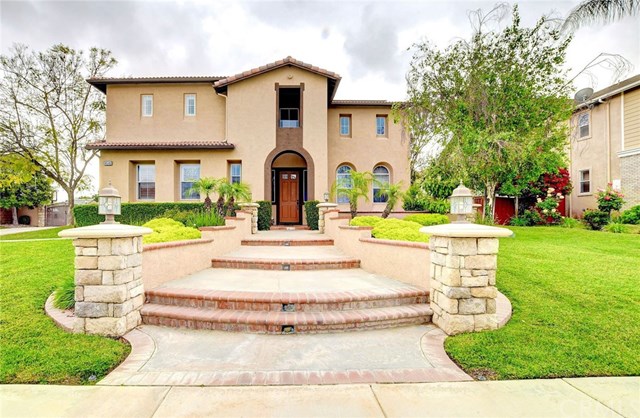 a front view of a house with garden and trees