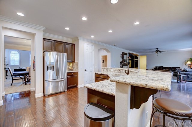 8546 Millpond Place Riverside, CA 92508 - Photo 13 of 60 a kitchen with stainless steel appliances granite countertop a refrigerator a stove and a dining table with wooden floor