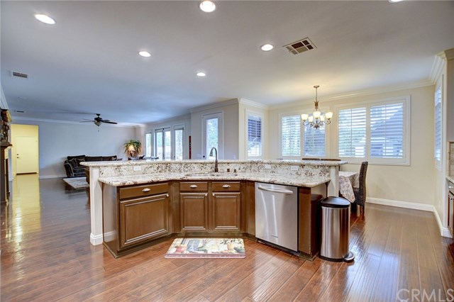 8546 Millpond Place Riverside, CA 92508 - Photo 14 of 60 a kitchen with granite countertop kitchen island wooden floors and stainless steel appliances