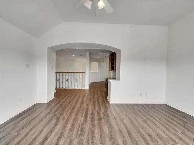 a view of empty room with wooden floor and a ceiling fan