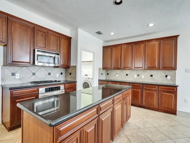 a kitchen with stainless steel appliances granite countertop a stove a sink dishwasher a refrigerator and a oven