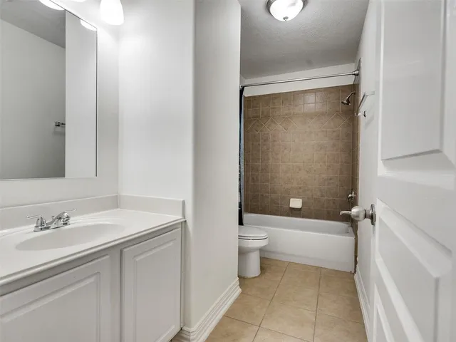 a kitchen with a sink dishwasher a stove and white cabinets with wooden floor