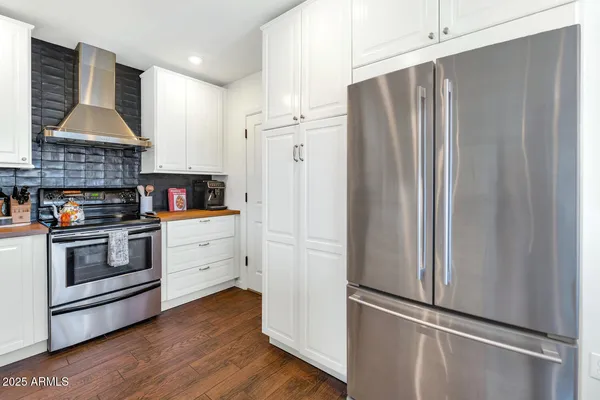 a kitchen with stainless steel appliances a refrigerator stove and cabinets