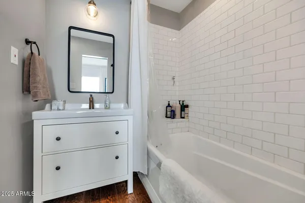 a bathroom with a tub a sink and mirror