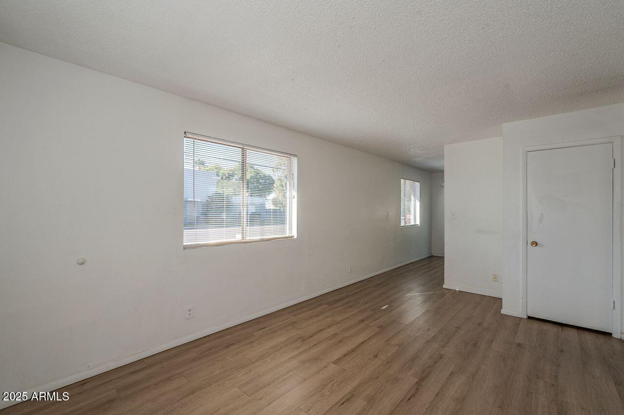 2608 West Ocotillo Road Phoenix, AZ 85017 - Photo 14 of 56 a view of an empty room with wooden floor and a window
