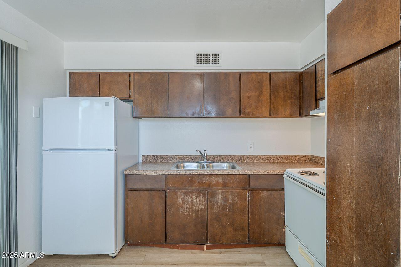 2608 West Ocotillo Road Phoenix, AZ 85017 - Photo 17 of 56 a kitchen with a sink a stove and a refrigerator