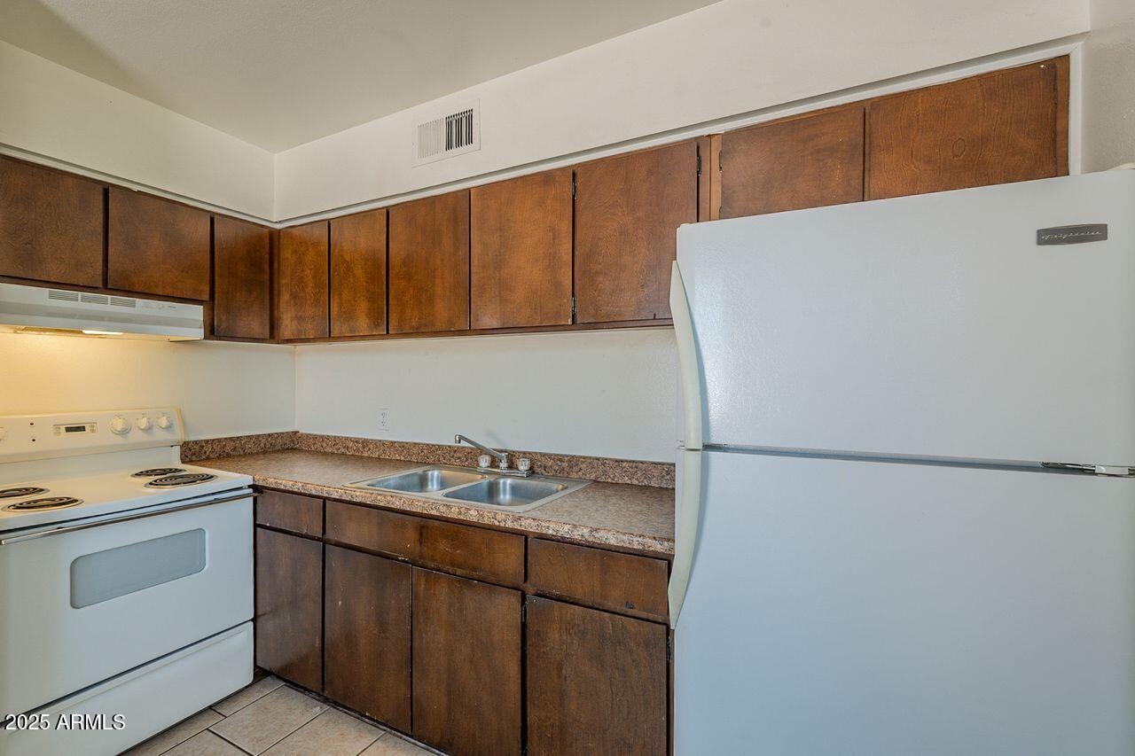 2608 West Ocotillo Road Phoenix, AZ 85017 - Photo 37 of 56 a kitchen with a sink a stove a refrigerator and cabinets