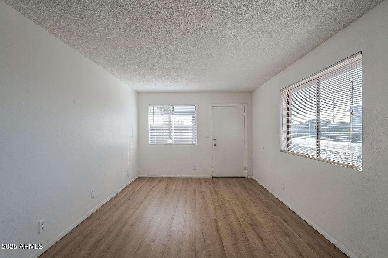 2608 West Ocotillo Road Phoenix, AZ 85017 - Photo 9 of 56 an empty room with wooden floor and windows