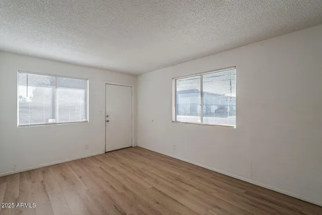 a view of an empty room with wooden floor
