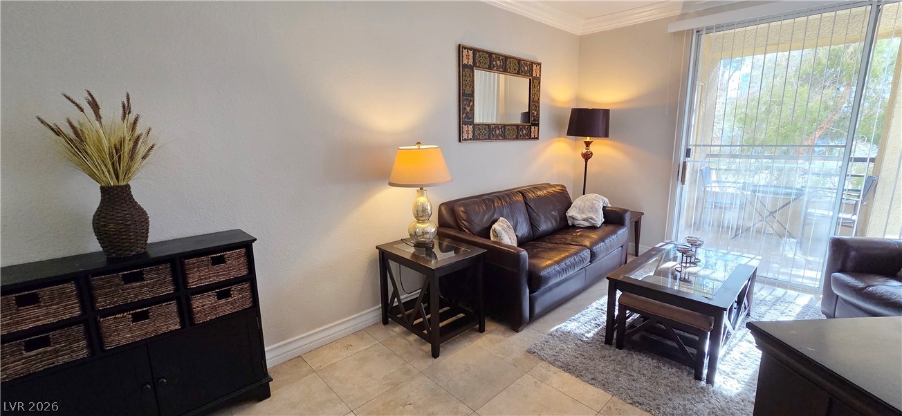 210 East Flamingo Road, Unit 208 Las Vegas, NV 89169 - Photo 6 of 42 Step into a sun-filled living space featuring durable tile flooring and access to a relaxing balcony.