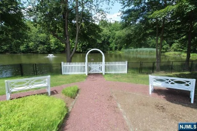 a view of a lake with a garden and a bench