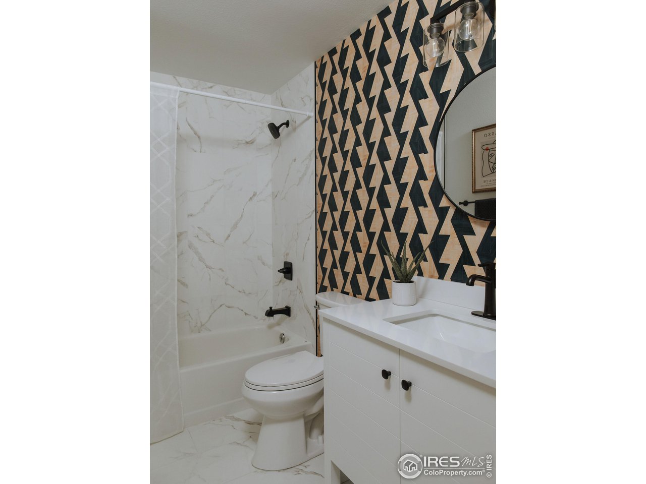 648 Justice Drive Fort Collins, CO 80526 - Photo 23 of 32 a bathroom with a granite countertop toilet and a shower curtain