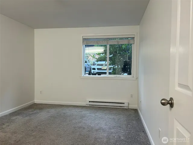 a bedroom with a bed and a lamp on dresser