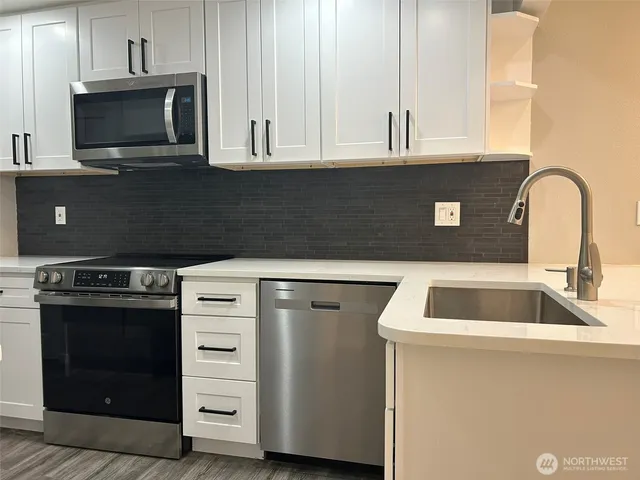 a kitchen with a stove microwave and sink