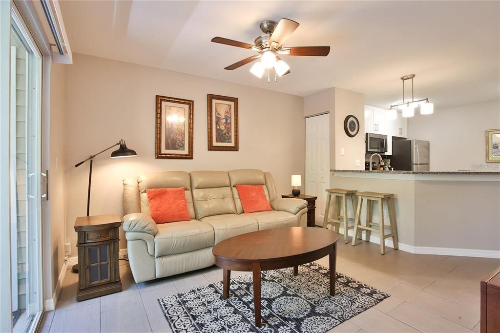 850 South Tamiami Trail, Unit 409 Sarasota, FL 34236 - Photo 3 of 22 a living room with furniture a fireplace and a chandelier