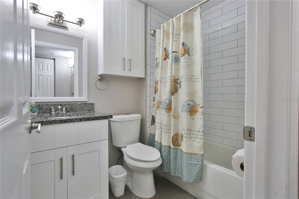 850 South Tamiami Trail, Unit 409 Sarasota, FL 34236 - Photo 8 of 22 a bathroom with a granite countertop sink a toilet and shower