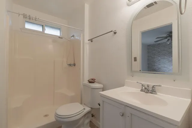 a bathroom with a sink toilet vanity and shower
