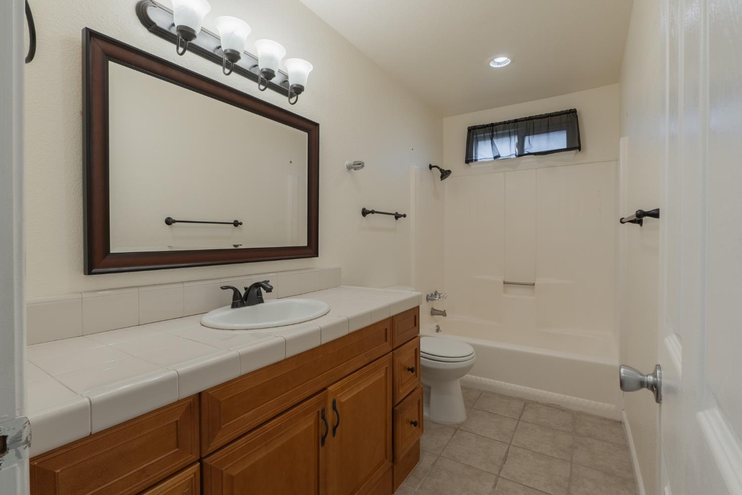 559 Perry Avenue Corcoran, CA 93212 - Photo 10 of 12 a bathroom with a sink a toilet and a mirror