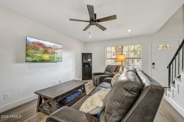a living room with furniture a window and a ceiling fan