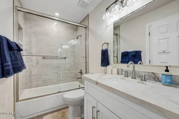 a bathroom with a bathtub shower sink vanity and toilet