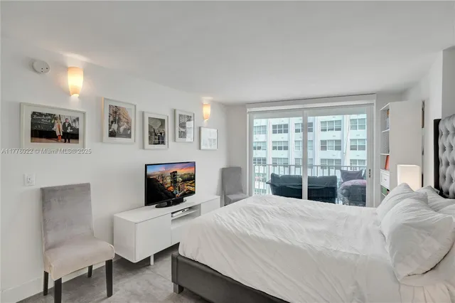 a bedroom with a bed a couch and a flat tv screen