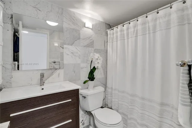 a bathroom with a sink a toilet and shower curtain