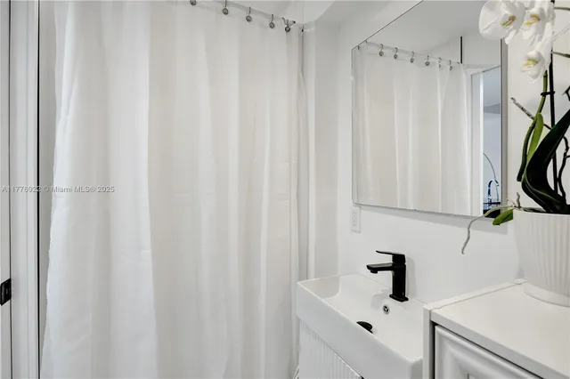a bathroom with a sink and a shower curtain