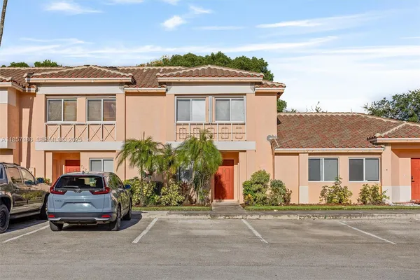 a car parked in front of a white house