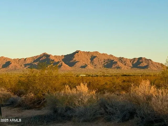 a view of a large mountain with mountains in the background
