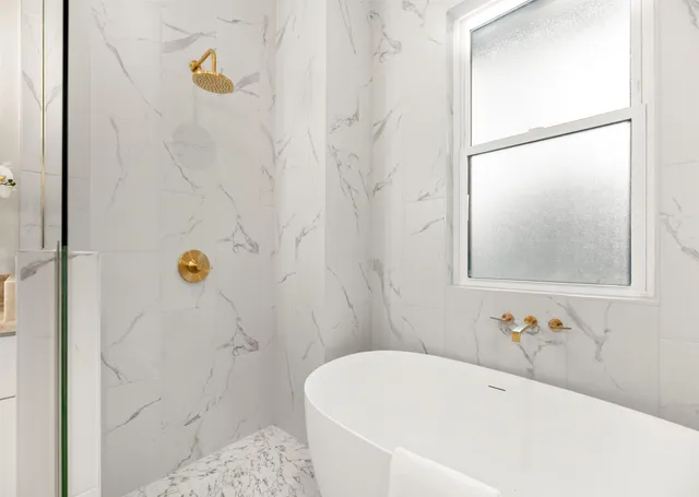 a bathroom with a sink vanity granite toilet and shower