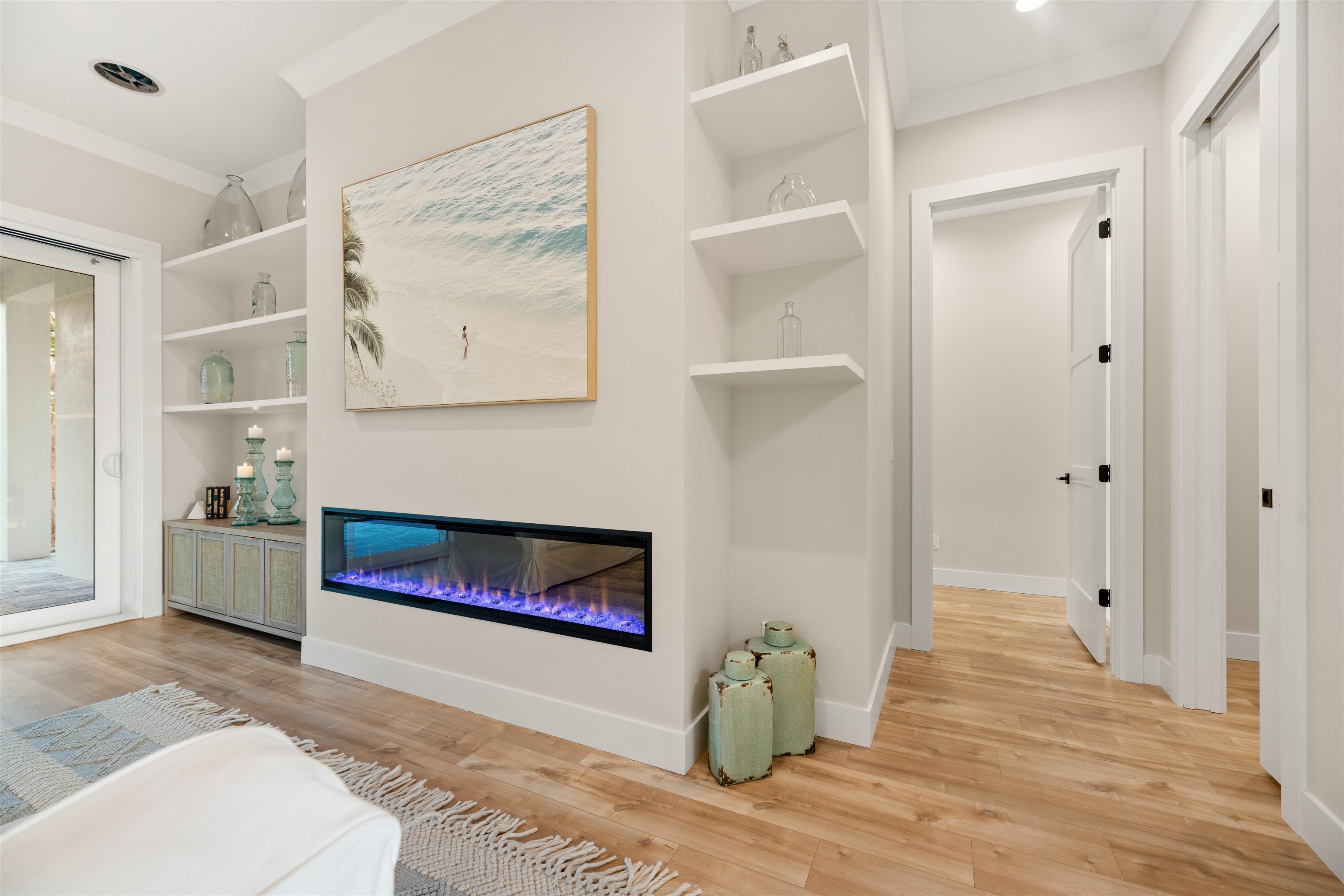 2549 Palm Avenue Flagler Beach, FL 32136 - Photo 34 of 70 Living area featuring crown molding, built in shelves, light wood finished floors, a glass covered fireplace, and recessed lighting