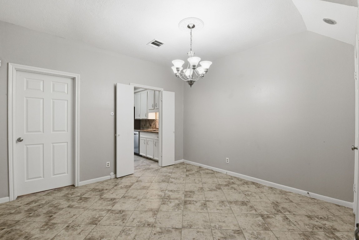 727 Bunker Hill Road, Unit 34 Houston, TX 77024 - Photo 13 of 50 Bright, open dining area with elegant chandelier, tile floors, and generous natural light