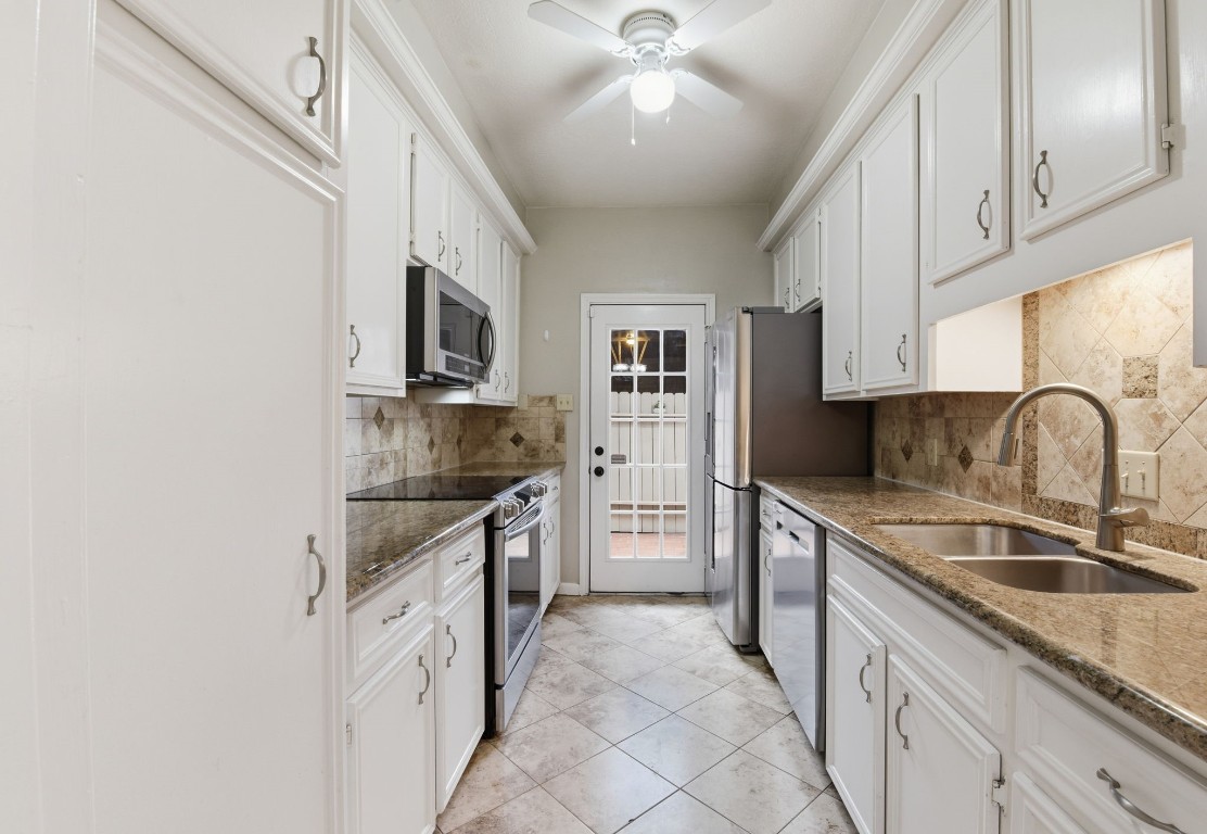 727 Bunker Hill Road, Unit 34 Houston, TX 77024 - Photo 20 of 50 Well-appointed kitchen with white cabinetry, stainless steel appliances, stone backsplash, and tile floors