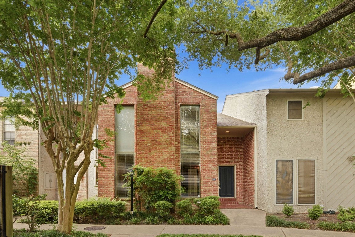 727 Bunker Hill Road, Unit 34 Houston, TX 77024 - Photo 2 of 50 Inviting brick entry with bold navy front door, lush greenery, and timeless charm