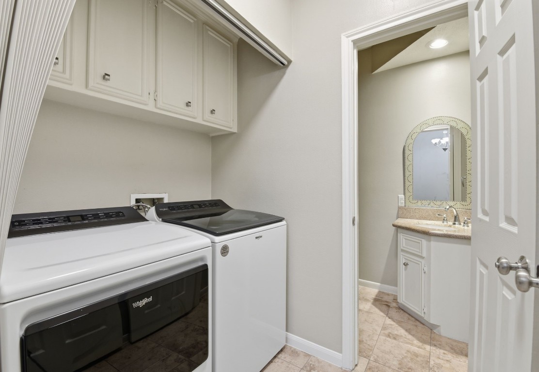 727 Bunker Hill Road, Unit 34 Houston, TX 77024 - Photo 22 of 50 Convenient utility area with washer and dryer included with sale, white cabinetry, and adjacent half bath