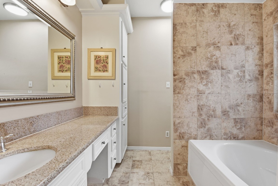 727 Bunker Hill Road, Unit 34 Houston, TX 77024 - Photo 29 of 50 Luxurious primary bathroom featuring double vanity, stone tile surround, and soaking tub