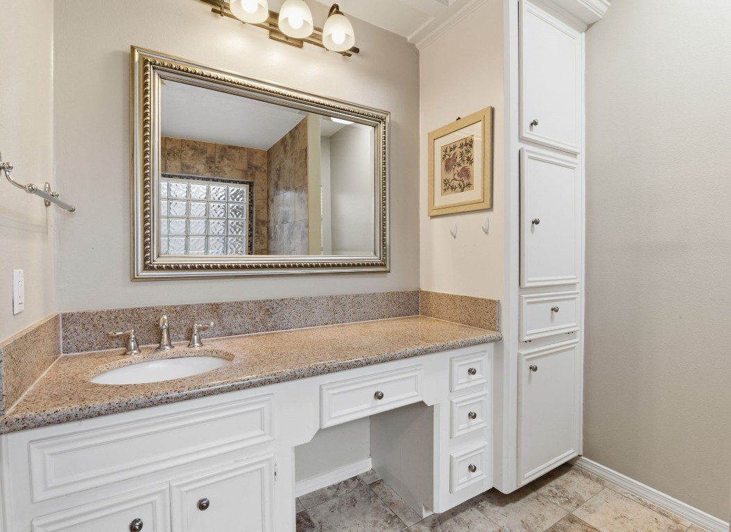 727 Bunker Hill Road, Unit 34 Houston, TX 77024 - Photo 30 of 50 Elegant primary bathroom with large framed mirror, double vanity with built-in storage, and stone tile surround